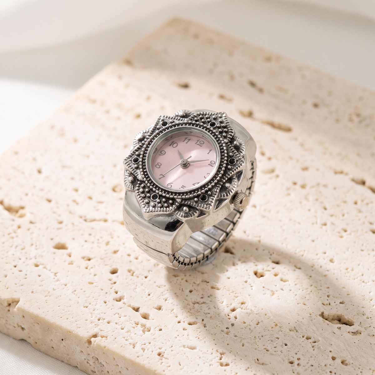 TIME — bague montre cadran rose, finition argentée, sur travertin crème