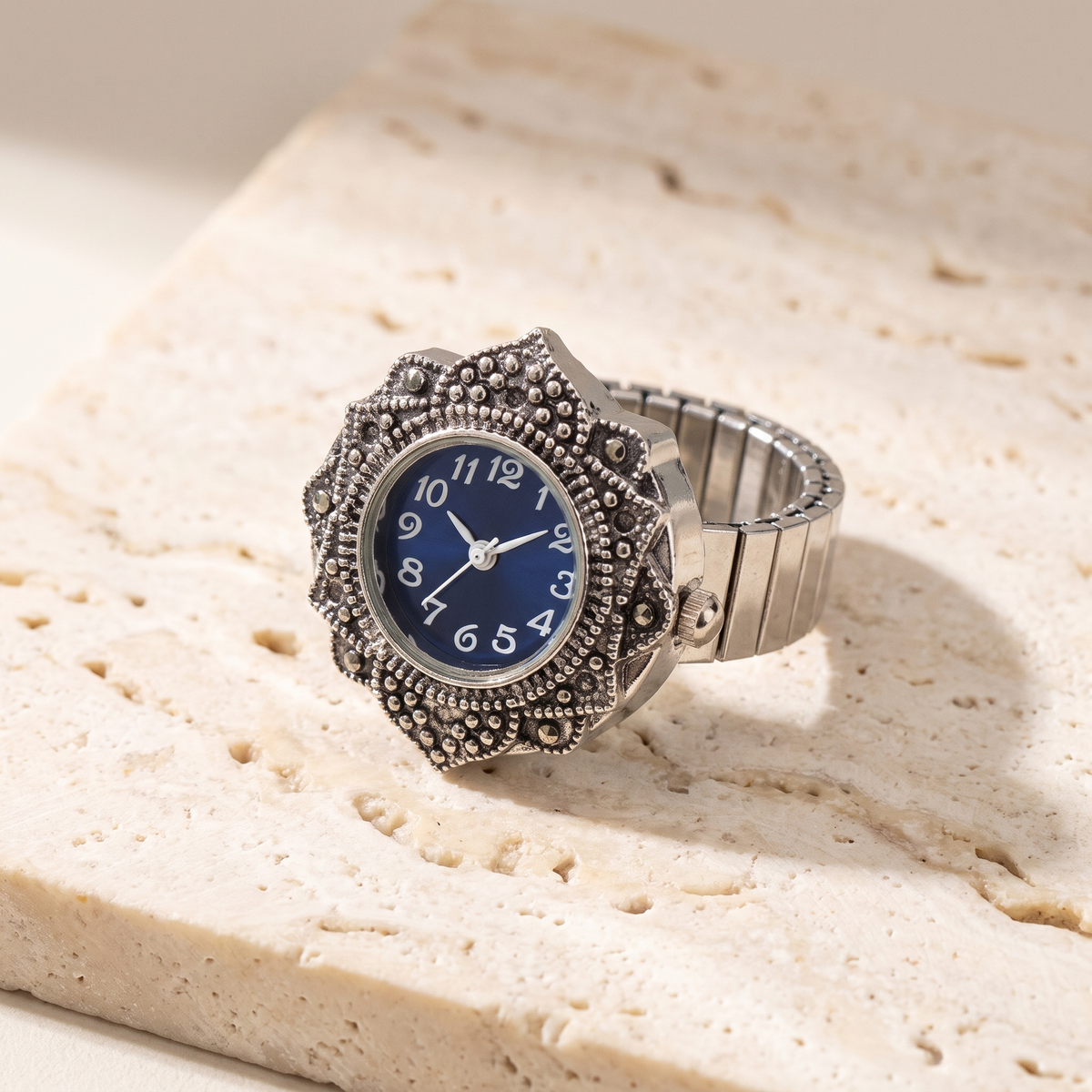 TIME — bague montre cadran bleu nuit, finition argentée, sur travertin crème